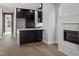 Open-concept kitchen with black cabinets, a white waterfall island, stainless steel appliances, and a fireplace at 226 Woodsborough Pl, Raleigh, NC 27601