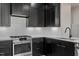 A contemporary kitchen features black cabinets, stainless steel appliances and hardware, and a white backsplash at 226 Woodsborough Pl, Raleigh, NC 27601