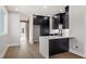 Modern kitchen with sleek black cabinetry, stainless steel appliances, and a waterfall island with seating for two at 226 Woodsborough Pl, Raleigh, NC 27601