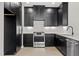 Contemporary kitchen featuring sleek, black cabinetry, stainless steel appliances, and a modern white backsplash at 226 Woodsborough Pl, Raleigh, NC 27601