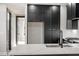 Modern kitchen featuring black cabinets, a stainless steel sink, and sleek quartz countertops offer a chic, functional space at 226 Woodsborough Pl, Raleigh, NC 27601