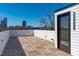 Expansive rooftop deck with wood tile flooring and city skyline views on a clear, sunny day at 226 Woodsborough Pl, Raleigh, NC 27601