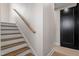 Stairway featuring hardwood treads and handrail and white risers and walls at 226 Woodsborough Pl, Raleigh, NC 27601