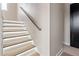 Modern stairway with recessed lighting on each step and a sleek wooden handrail creates an inviting ambiance at 226 Woodsborough Pl, Raleigh, NC 27601