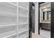 Walk-in closet boasting custom white shelving and a black trimmed doorway to bathroom at 226 Woodsborough Pl, Raleigh, NC 27601