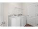 Bright laundry area with a white washer and dryer, shelving, and a white door at 23 Juliette Dr, Durham, NC 27713