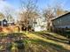 View of the home's back exterior, yard, deck with pergola, and mature trees at 2511 State St, Durham, NC 27704