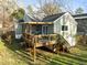 The home's back exterior features a wood deck with pergola, railing, staircase, and verdant backyard at 2511 State St, Durham, NC 27704