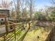 The spacious backyard features mature trees, a wooden fence, and the home's wood deck at 2511 State St, Durham, NC 27704