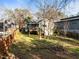 View of the private backyard with mature trees, partial fencing, and wooden deck at 2511 State St, Durham, NC 27704