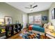 This vibrant bedroom features a colorful rug, ceiling fan, and charming decor with plenty of natural light at 2511 State St, Durham, NC 27704