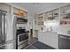 Well-equipped kitchen with stainless steel appliances, sleek white cabinetry, and open shelving at 2511 State St, Durham, NC 27704