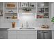Bright and modern kitchen featuring white cabinets, stainless steel appliances, and open shelving at 2511 State St, Durham, NC 27704