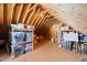 Open attic area with wooden beams, plywood floor, and abundant storage shelves with labeled bins at 27 Ellen Cir, Clayton, NC 27527