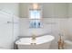 Elegant bathroom with freestanding tub, chandelier lighting, and wainscoting at 27 Ellen Cir, Clayton, NC 27527