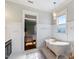 Well-lit bathroom with a soaking tub, tiled floors, wainscoting, and a view to the main bedroom at 27 Ellen Cir, Clayton, NC 27527