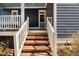 Charming front porch showing the wooden stairs leading up to the entrance and lovely blue ceiling at 27 Ellen Cir, Clayton, NC 27527