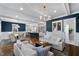 Inviting living room features an open floor plan, hardwood floors, white couches and a kitchen with a bar at 27 Ellen Cir, Clayton, NC 27527