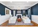 Elegant living room featuring hardwood floors, white sofas, fireplace, wainscotting and dark blue accent walls at 27 Ellen Cir, Clayton, NC 27527
