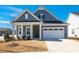Charming, traditional-style home featuring a two-car garage, blue siding, and a welcoming front porch at 276 Bevis Marks Dr, Fuquay Varina, NC 27526