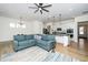Bright living room featuring a comfortable blue sofa and stylish open layout to the kitchen at 276 Bevis Marks Dr, Fuquay Varina, NC 27526