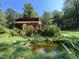 Lush backyard featuring a pond, deck, and natural scenery, perfect for outdoor enjoyment at 279 Box Turtle Trl, Chapel Hill, NC 27516
