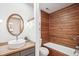 Modern bathroom features a wood accent wall and vanity with sleek fixtures next to a tub and shower at 279 Box Turtle Trl, Chapel Hill, NC 27516