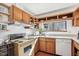 The eat-in kitchen features wood cabinets, a light countertop, and an adjacent window offering wooded views at 279 Box Turtle Trl, Chapel Hill, NC 27516