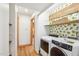 Bright laundry room with modern washer and dryer, complemented by lemon-themed wallpaper and wooden accents at 279 Box Turtle Trl, Chapel Hill, NC 27516