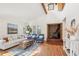 Cozy living room featuring a brick fireplace, wood floors, and comfortable seating at 279 Box Turtle Trl, Chapel Hill, NC 27516