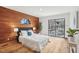 This main bedroom features hardwood floors, a wood accent wall, and a sliding door to a private deck at 279 Box Turtle Trl, Chapel Hill, NC 27516