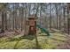 Backyard with a wooden playset, including a slide, climbing wall, and fort at 279 Box Turtle Trl, Chapel Hill, NC 27516