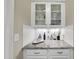 Stylish bar area with granite countertops, white cabinetry, and glass shelving for displaying glassware at 2851 Wilkes Lake Dr, Fuquay Varina, NC 27526