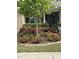 Charming home exterior featuring lush landscaping surrounding a tree with rose bushes at 2851 Wilkes Lake Dr, Fuquay Varina, NC 27526