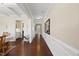 Elegant hallway featuring hardwood floors, classic wainscoting, and a view of the dining room at 2851 Wilkes Lake Dr, Fuquay Varina, NC 27526