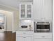 Close up of a kitchen with white cabinets, stone countertops, stainless steel microwave, and herringbone backsplash at 2851 Wilkes Lake Dr, Fuquay Varina, NC 27526