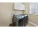 Laundry room with a front loading washer and dryer and white cabinets above at 2851 Wilkes Lake Dr, Fuquay Varina, NC 27526