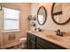 Bathroom featuring dual sinks, vanity, oval mirrors, and a window at 290 Silver Creek Dr, Clayton, NC 27520