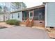 Rear patio and screened porch of the home with a concrete landing and brick skirting at 290 Silver Creek Dr, Clayton, NC 27520