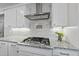 Close up on the kitchen with a gas cooktop, white cabinets, and granite countertops at 2907 Jakes View Pt, Fuquay Varina, NC 27526