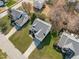 An aerial view showcases the home with a driveway, mature trees and surrounding manicured lawns at 3003 Cregler Dr, Apex, NC 27502