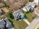 An aerial view showcases the home with a driveway, mature trees and surrounding manicured lawns at 3003 Cregler Dr, Apex, NC 27502
