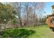 A beautifully landscaped backyard with mature trees and a gentle slope is great for outdoor living at 3003 Cregler Dr, Apex, NC 27502