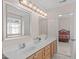 Large bathroom with double sinks and wood cabinetry, vanity mirrors and bright lighting above each mirror at 3003 Cregler Dr, Apex, NC 27502