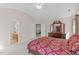 Bright bedroom with ensuite bathroom features a patterned comforter and antique hutch with many mirrors at 3003 Cregler Dr, Apex, NC 27502