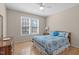 Cozy bedroom with a ceiling fan, a patterned bedspread, and natural light from the window at 3003 Cregler Dr, Apex, NC 27502