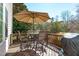 Wooden deck furnished with a round table and chairs, shaded by a large umbrella at 3003 Cregler Dr, Apex, NC 27502