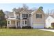 Charming two-story home featuring a manicured lawn, attached garage, and covered front porch at 3003 Cregler Dr, Apex, NC 27502