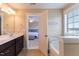 Bright bathroom featuring dual sinks, soaking tub, a window and views of the bedroom at 319 Brinkley Cir, Mebane, NC 27302