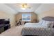 Cozy bedroom featuring neutral walls, plush carpet, a ceiling fan, and a patterned blue and white bedspread at 319 Brinkley Cir, Mebane, NC 27302